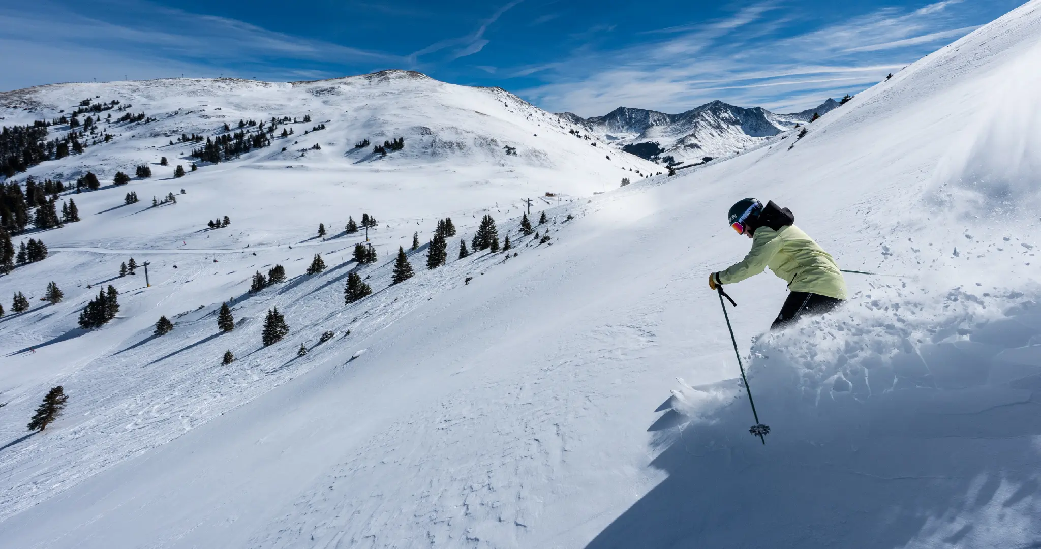 girl skiing fresh powder on a bluebird day